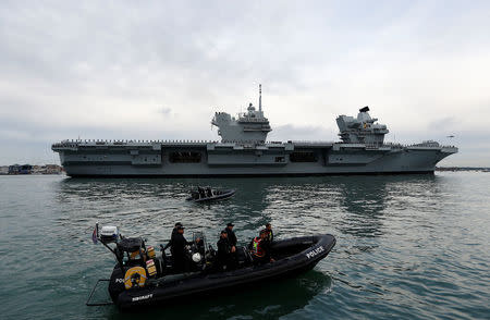 Police officers stand guard in a rigid inflatable boat (RIB) as the Royal Navy's new aircraft carrier HMS Queen Elizabeth arrives in Portsmouth, Britain August 16, 2017. REUTERS/Peter Nicholls