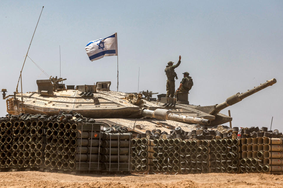  An Israeli army soldier gestures as he stands atop the turret of a main battle tank positioned in southern Israel near the border with the Gaza Strip. (Photo by AHMAD GHARABLI / AFP) (Photo by Ahmad Gharabli/AFP via Getty Images)