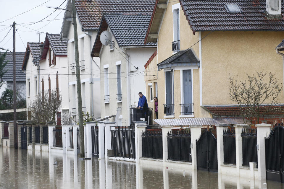 <p>People watch a flooded street of Villeneuve-Saint-Georges, outside Paris, where the Yerres river flooded on Thursday, Jan.25, 2018. (Photo: Thibault Camus/AP) </p>