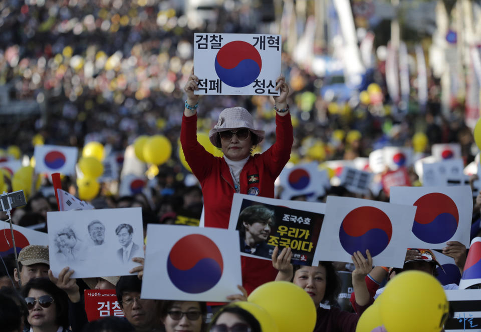 A pro-government supporter holds a sign before a rally supporting Justice Minister Cho Kuk in front of Seoul Central District Prosecutors' Office in Seoul, South Korea, Saturday, Oct. 12, 2019. The letters read "Reform the Prosecution". Tens of thousands of government supporters have gathered in South Korea’s capital for the fourth-straight weekend to show their support for President Moon Jae-in’s controversial justice minister who’s enmeshed in explosive political scandal that rocked and polarized the nation.(AP Photo/Lee Jin-man)