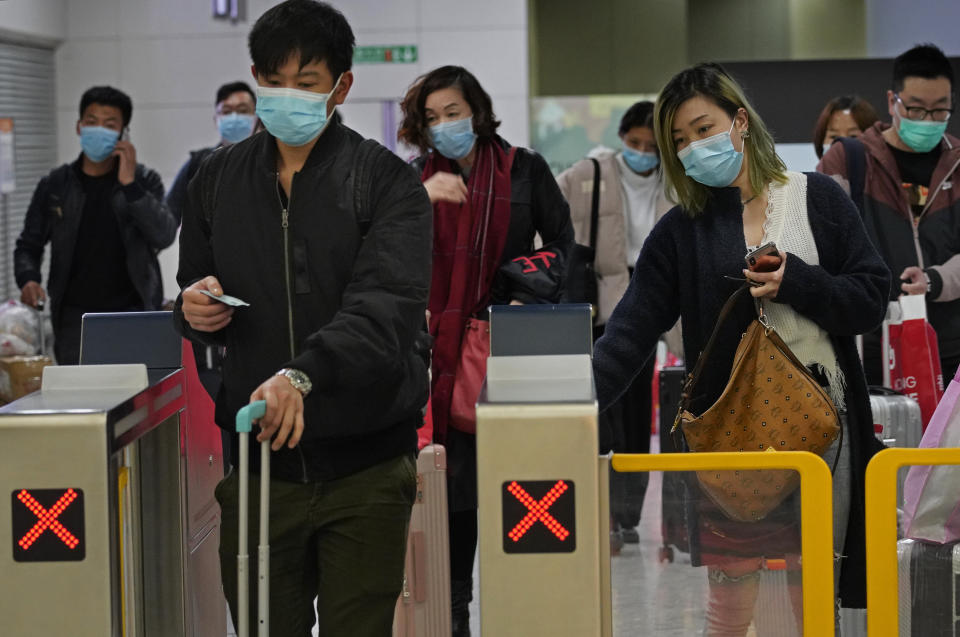 Passengers wear protective face masks arrive at the high speed train station in Hong Kong, Tuesday, Jan. 28, 2020. Hong Kong's leader has announced that all rail links to mainland China will be cut starting Friday as fears grow about the spread of a new virus. (AP Photo/Vincent Yu)