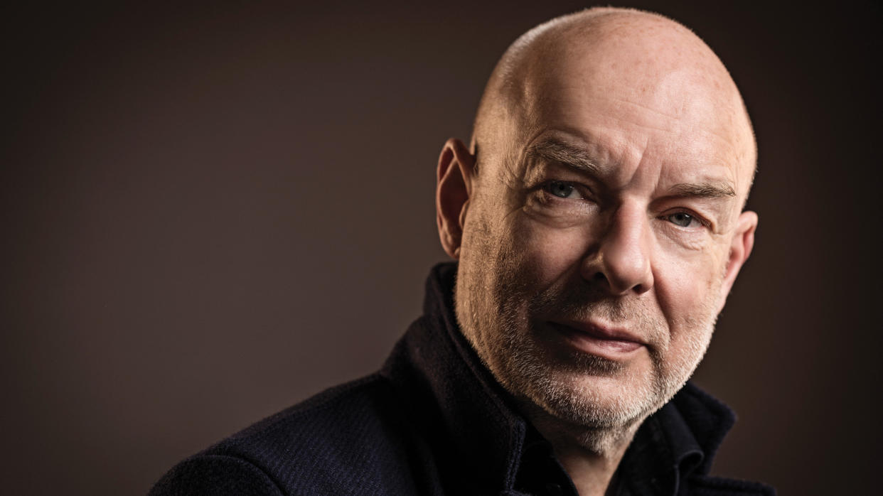  Brian Eno 2016 solo shot against a dark background 