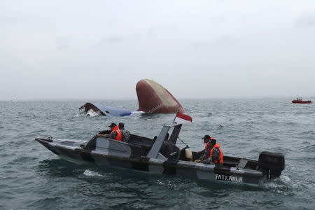 An Indonesia rescue team approaches the sunken Antigua and Barbuda flagged freighter MV Thorco Cloud which sank after colliding with a tanker the night before, in the Singapore Strait off the Indonesian island of Batam December 17, 2015 in this photo taken by Antara Foto. REUTERS/M N Kanwa/Antara Foto