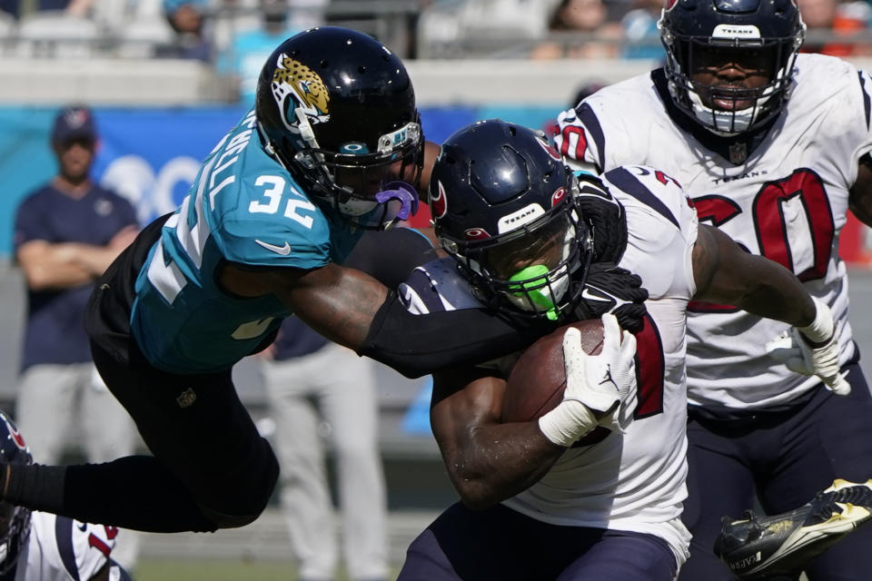 Jacksonville Jaguars cornerback Tyson Campbell (32) tackles Houston Texans running back Dameon Pierce (31) during the second half of an NFL football game in Jacksonville, Fla., Sunday, Oct. 9, 2022. (AP Photo/John Raoux)