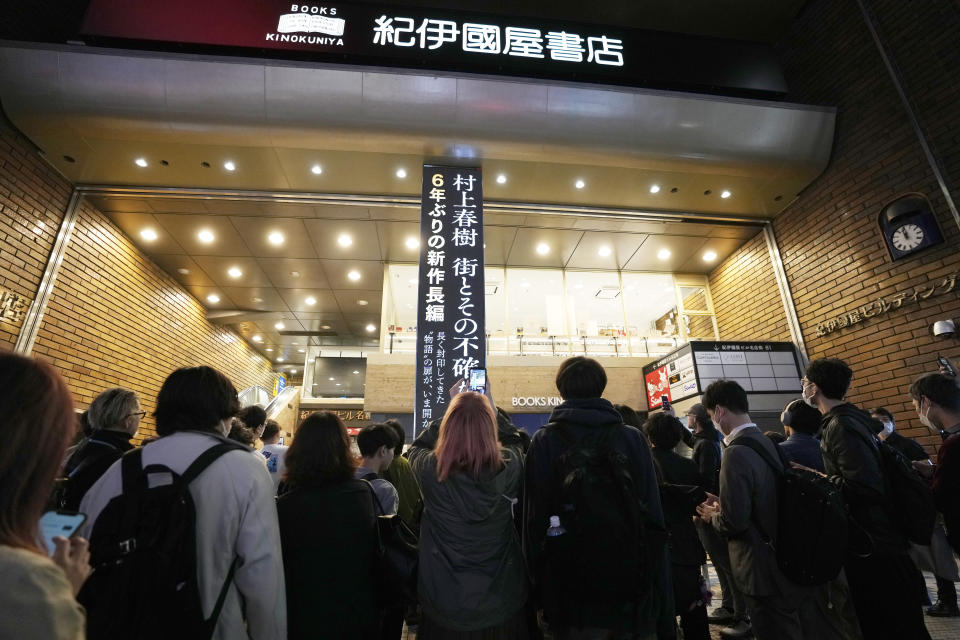 Fans of Japanese writer Haruki Murakami queue to buy his new novel "The City and Its Uncertain Walls" at Kinokuniya bookstore in Shinjuku district early Thursday, April 13, 2023, in Tokyo. Murakami wrote a story of a walled city when he was fresh off his debut. More than four decades later, as a seasoned and acclaimed novelist, he gave it a new life as “The City and Its Uncertain Walls.”(AP Photo/Mari Yamaguchi)