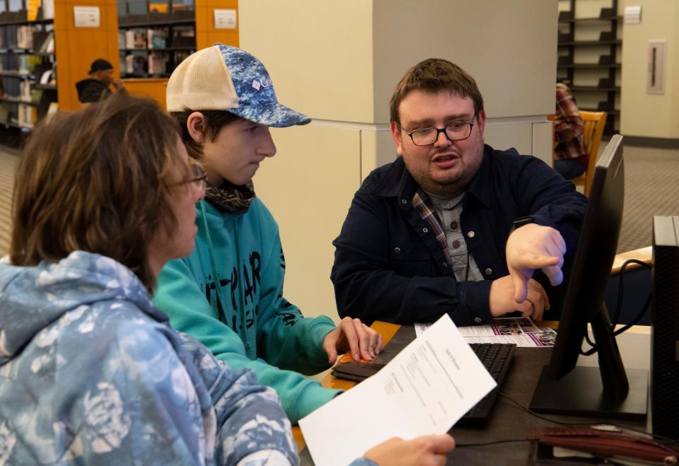 Dawn Branson, left, and Seth Branson, center, receive help with setting up a resume from Tech & Reference Librarian Jake Kohlmeyer at Evansville Vanderburgh Public Library Central Thursday afternoon, Jan. 5, 2023.
