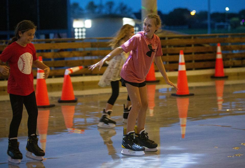 Mackenzie Morgan, 11, reaches for Brooke Ganley, 9, while ice skating at the Portland Community Center Pavilion, Dec. 16, 2021, in Portland, Texas.