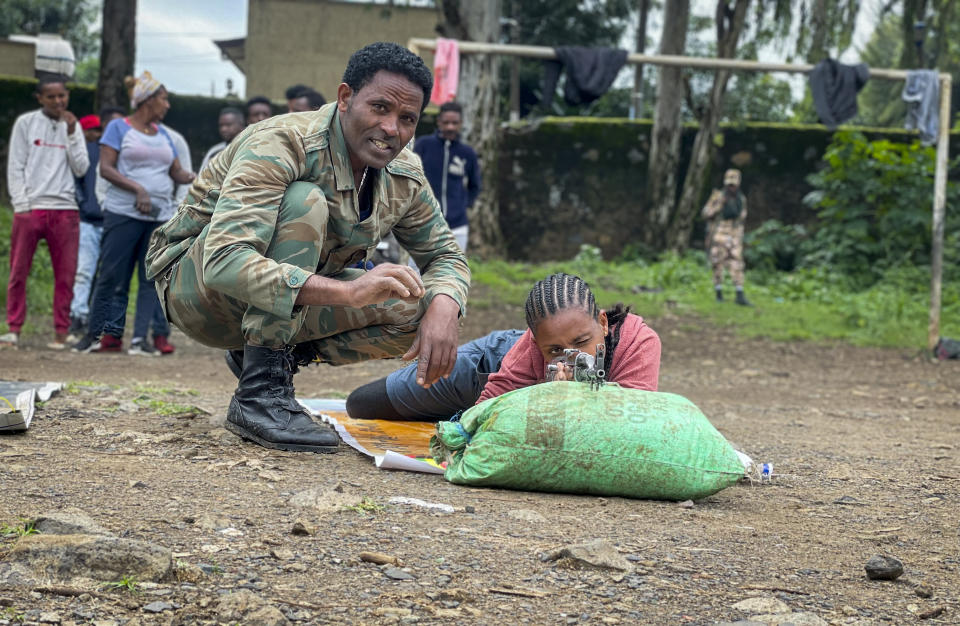 New volunteer Mekdess Muluneh Asayehegn, right, and others receive basic training to become potential reinforcements for pro-government militias or military forces, in a school courtyard in Gondar, in the Amhara region of northern Ethiopia Tuesday, Aug. 24, 2021. As they bring war to other parts of Ethiopia such as the Amhara region, resurgent Tigray fighters face growing allegations that they are retaliating for the abuses their people suffered back home, sending hundreds of thousands of people fleeing in the past two months. (AP Photo)