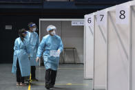 Medical professionals collect nasal swab sample at a makeshift testing site in the Queen Elizabeth Stadium in Hong Kong Tuesday, Sept. 1, 2020. Hong Kong began a voluntary mass-testing program for coronavirus Tuesday as part of a strategy to break the chain of transmission in the city's third outbreak of the disease. (Anthony Kwan /Pool Photo via AP)