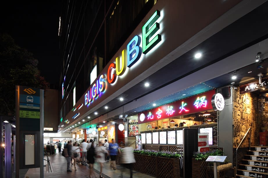 Pedestrians walking past the restaurants on the ground floor of Bugis Cube.