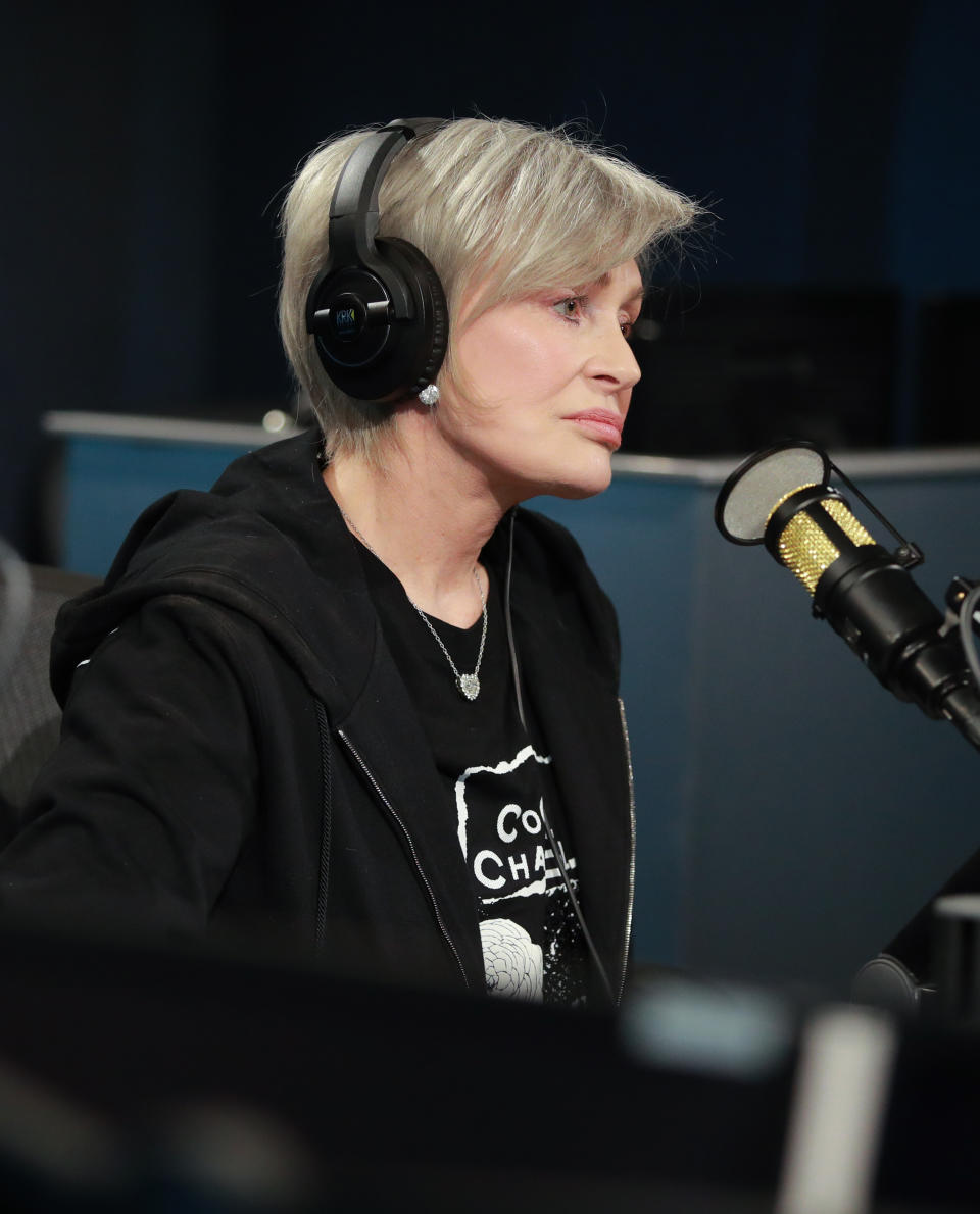 Sharon Osbourne wearing headphones as she sits in front of a mic