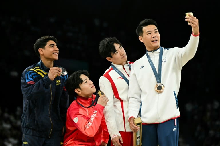 (De izquierda a derecha) El colombiano Ángel Barajas (plata), el japonés Shinnosuke Oka, el chino Zhang Boheng y el taiwanés Chia-Hung Tang (bonces) posan para una selfi en el podio de la prueba de barra fija de los Juegos Olímpicos de París, en el Bercy Arena de la capital francesa el 5 de agosto de 2024 (Gabriel BOUYS)