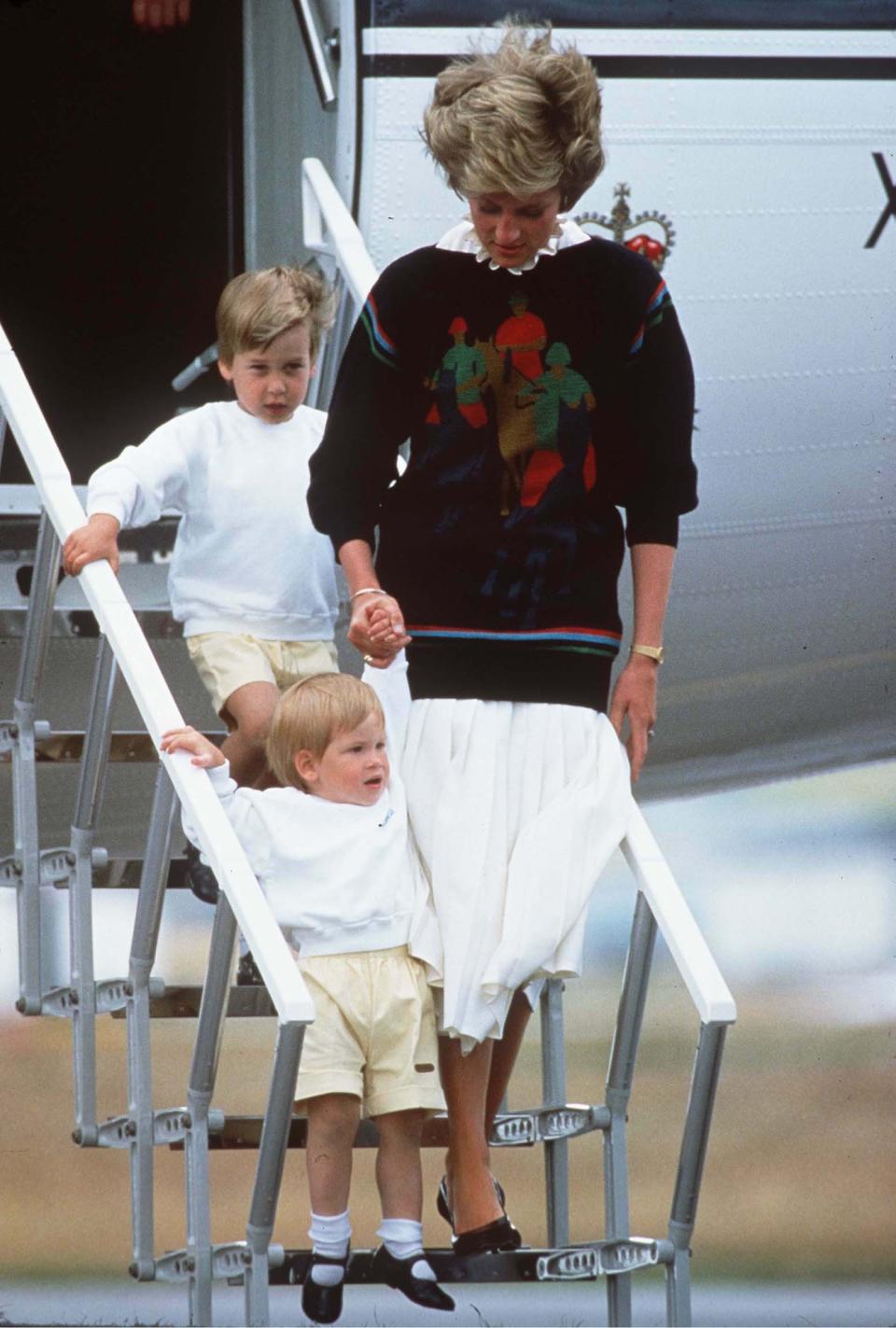 <p>Princess Diana clutches the hand of a young Prince Harry as big brother William follows on behind. [Photo: PA Images] </p>