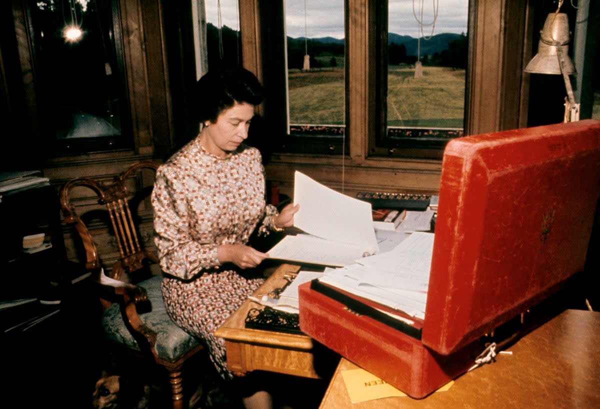 The Queen working through her red box of official papers at Balmoral (PA) (PA Archive)