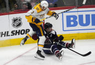Nashville Predators defenseman Jeremy Lauzon, left, gets tangled up with Colorado Avalanche right wing Mikko Rantanen as they battle for the puck in the third period of an NHL hockey game Saturday, March 30, 2024, in Denver. (AP Photo/David Zalubowski)