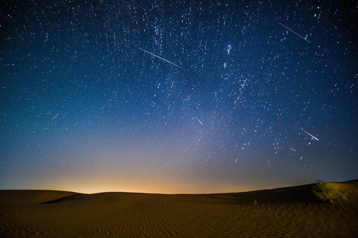 Photomontage taken on Aug. 13, 2021 shows the night sky during the Perseid Meteor Shower above an ecological demonstration zone of Engebei in Kubuqi Desert, north China's Inner Mongolia Autonomous Region.