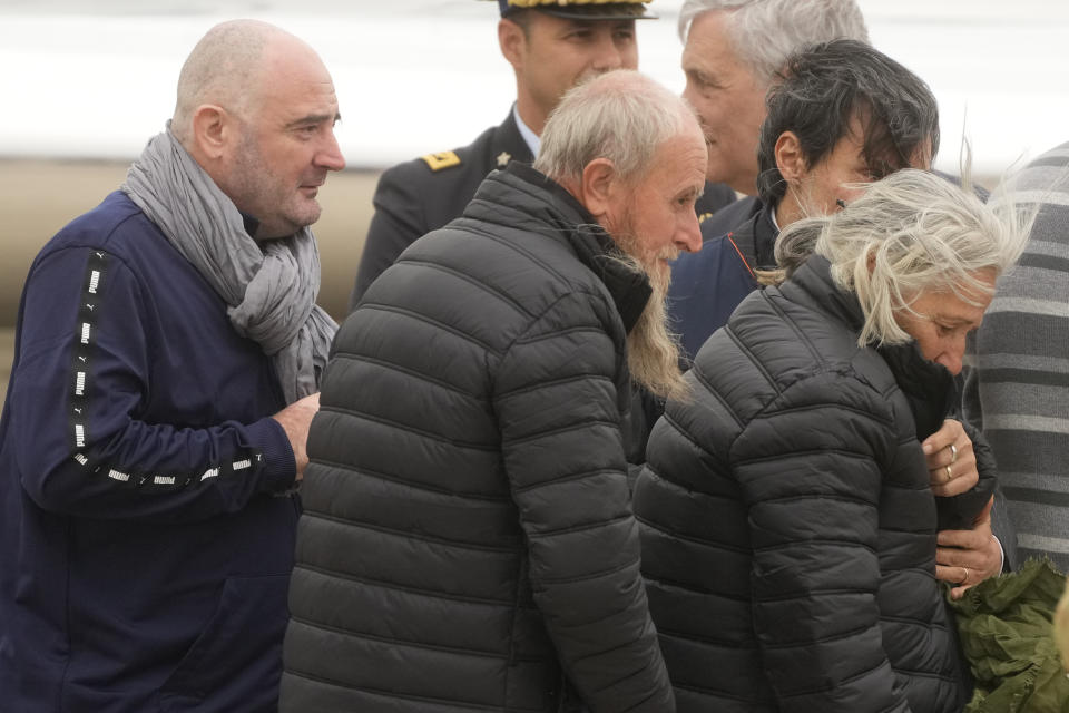 Rocco Antonio Langone, centre, his wife Maria Donata Caivano and his son Giovanni arrive at Ciampino at military airport, in Rome, Tuesday, Feb. 27, 2024. The Italian family who was kidnapped by an al Qaida-linked group on May 19, 2022 in their home on the outskirts of the city of Koutiala, south-east of the capital of Mali, Bamako, were freed last night, the Italian Foreign Ministry said.(AP Photo/Gregorio Borgia)