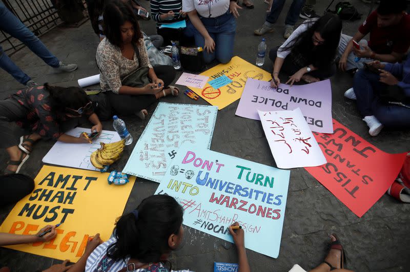 Demonstrators create posters during a protest against attacks on the students of New Delhi's Jawaharlal Nehru University (JNU), outside the Gateway of India monument in Mumbai