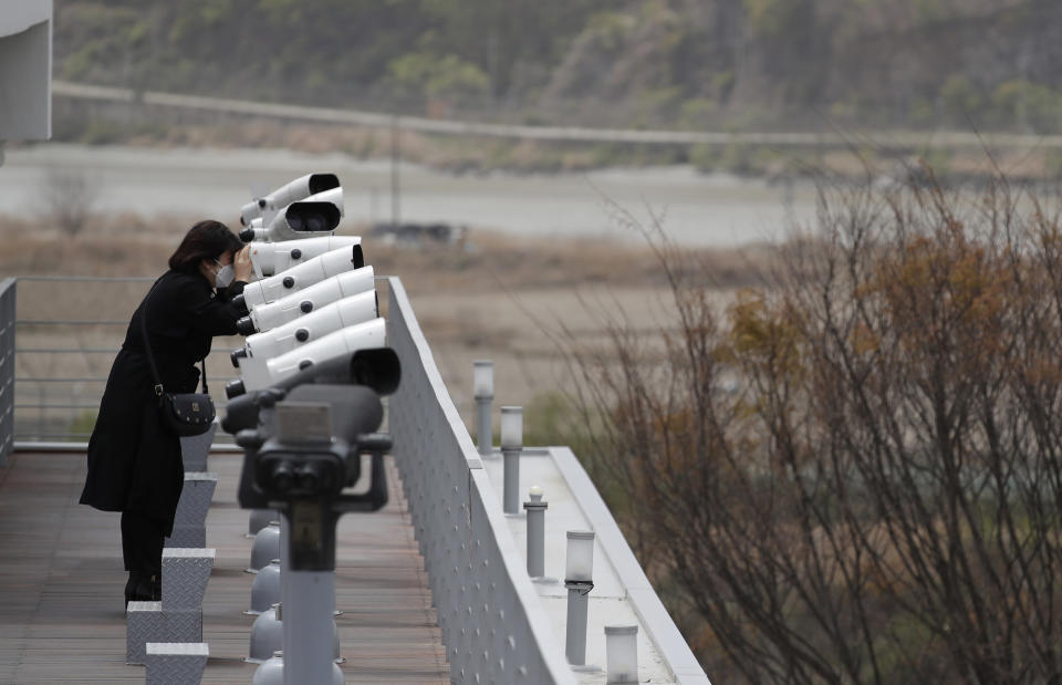 A visitor uses binoculars to see the northern side at the Imjingak Pavilion in Paju, South Korea, Wednesday, April 22, 2020. South Korean officials reported no unusual activity in North Korea on Tuesday following unconfirmed media reports that leader Kim Jong Un was in fragile health after surgery. (AP Photo/Lee Jin-man)