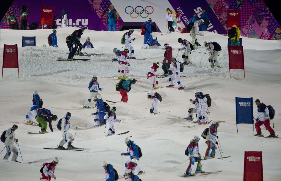 Athletes take part in a moguls course inspection prior to a freestyle skiing training run at the 2014 Sochi Winter Olympics in Krasnaya Polyna, Russia, Wednesday, Feb. 5, 2014. (AP Photo/The Canadian Press, Jonathan Hayward)