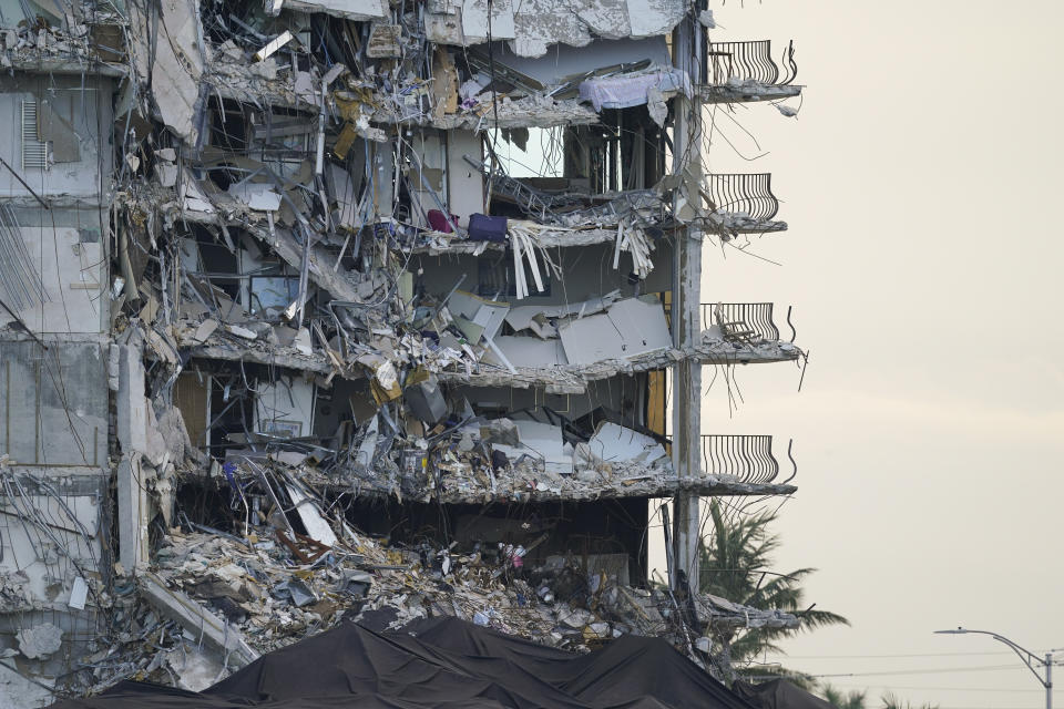 FILE - A giant tarp covers a section of rubble where search and rescue personnel have been working at the Champlain Towers South condo building, as demolition experts were preparing to bring down the precarious still-standing portion, Sunday, July 4, 2021, in Surfside, Fla. A nearly $1 billion tentative settlement has been reached in a class-action lawsuit brought by families of victims and survivors of last June's condominium collapse in Surfside, Fla., an attorney said Wednesday, May 11, 2022. (AP Photo/Lynne Sladky, File)