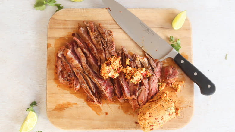 chipotle steak with butter and knife on cutting board