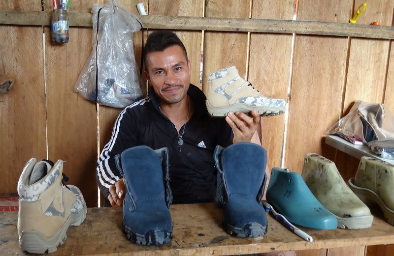 Foto de archivo. Un exrebelde de las FARC muestra un zapato hecho por él en una ciudadela construida por ellos en Caquetá