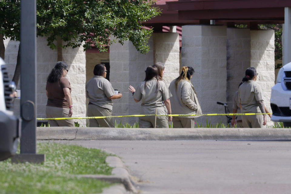 Female inmates move between buildings at the Federal Prison Camp where Elizabeth Holmes, the former founder and CEO of Theranos, is expected to arrive to begin her 11 year sentence for fraud relating to the defunct company Tuesday, May 30, 2023, in Bryan, Texas. (AP Photo/Michael Wyke)