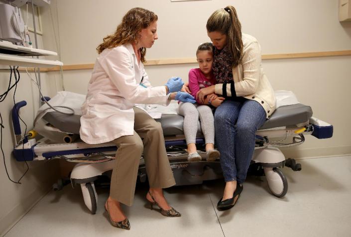 A pediatrician prepares to administer a vaccination to a young girl, at the Miami Children's Hospital in Florida, on January 28, 2015 (AFP Photo/Joe Raedle)
