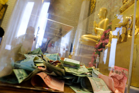 Thai bath banknotes are seen inside a donation box at a temple in Bangkok, Thailand, Octoboer 18, 2017. Picture taken October 18, 2017. REUTERS/Athit Perawongmetha