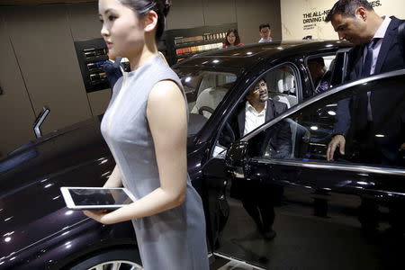 People check out the new BMW M760Li xDrive as it is presented during the Auto China 2016 auto show in Beijing April 25, 2016. REUTERS/Damir Sagolj