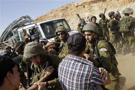 Israeli soldiers scuffle with Palestinians near a truck loaded with items European diplomats wanted to deliver to locals in the West Bank herding community of Khirbet al-Makhul, in the Jordan Valley September 20, 2013. REUTERS/Abed Omar Qusini