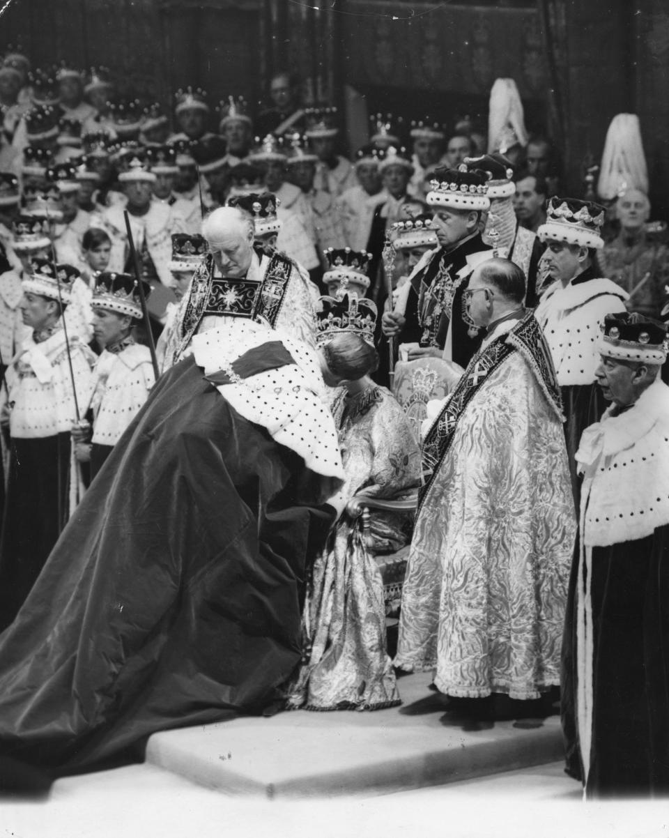 2nd June 1953:  Prince Philip, the Duke of Edinburgh giving a kiss of homage to the Queen during her coronation ceremony at Westminster Abbey.  (Photo by Central Press/Getty Images)