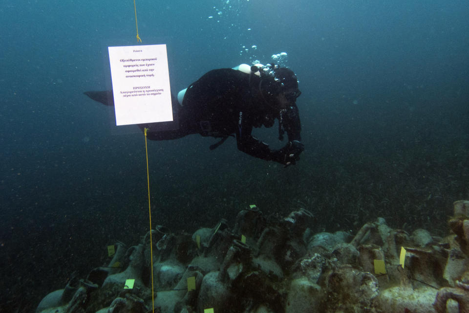 In this photo taken on Sunday, April 7, 2019, an archaeologists dives next ancient amphoras from a 5th Century B.C. shipwreck, the first ancient shipwreck to be opened to the public in Greece, including to recreational divers who will be able to visit the wreck itself, near the coast of Peristera, Greece. Greece’s rich underwater heritage has long been hidden from view, off-limits to all but a select few, mainly archaeologists. Scuba diving was banned throughout the country except in a few specific locations until 2005, for fear that divers might loot the countless antiquities that still lie scattered on the country’s seabed. Now that seems to be gradually changing, with a new project to create underwater museums. (AP Photo/Elena Becatoros)
