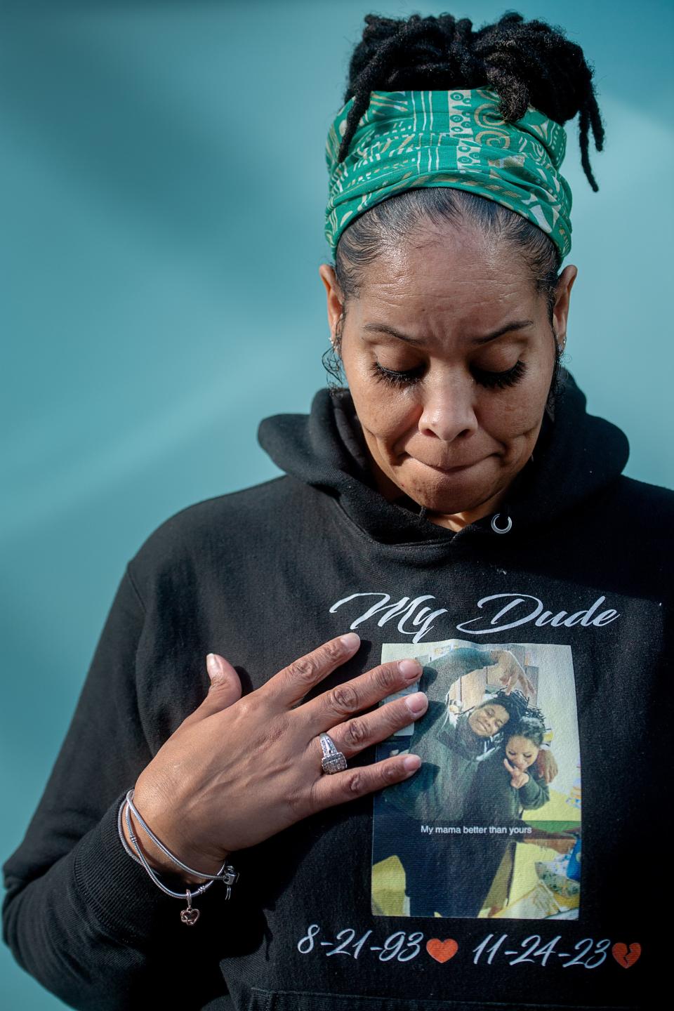 Patricia King looks down at her sweatshirt with a photo of her and her son, Elijah Timmons III, at the Henderson County Courthouse, March 4, 2024.