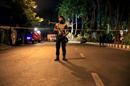 FILE PHOTO: A policeman stands guard outside a church, one of the three hit by suicide bombers in Surabaya, Indonesia May 13, 2018. Picture taken May 13, 2018. REUTERS/Beawiharta/File Photo
