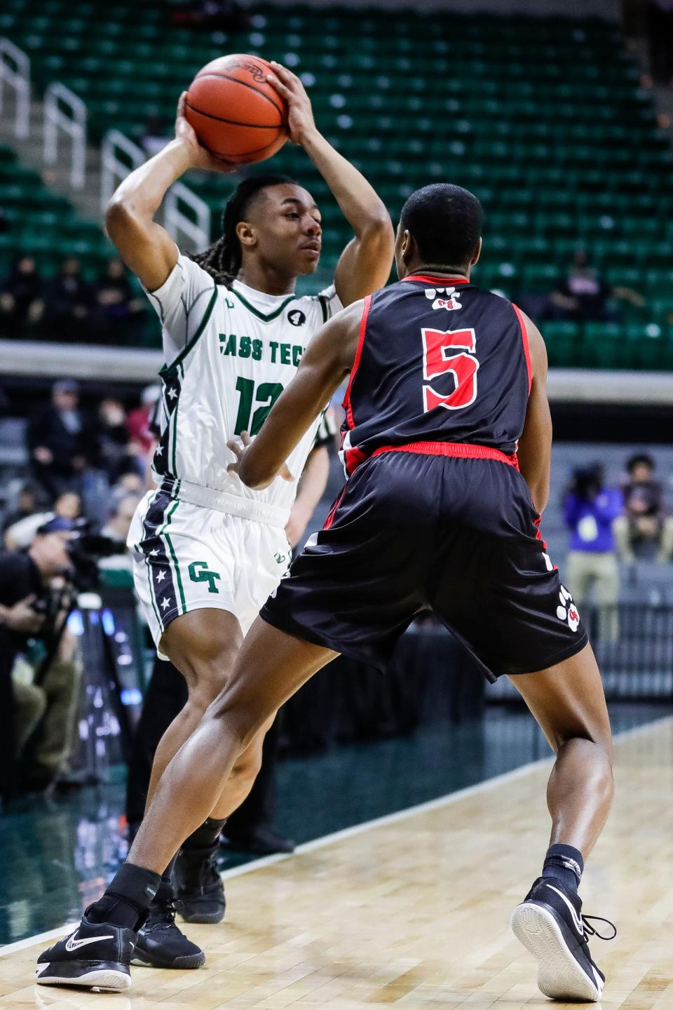 Detroit Cass Tech forward Lee Harris looks to pass against Grand Blanc forward Anthony Perdue during the first half of the Division 1 boys basketball semifinal at Breslin Center on Friday, March 24, 2023.