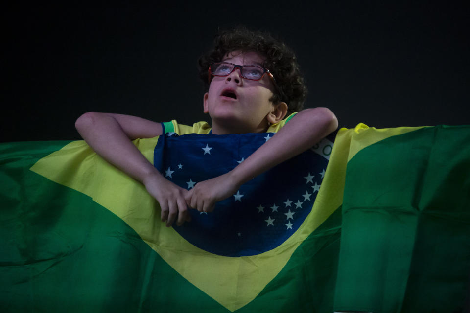 Un joven aficionado brasileño observa el partido de su equipo por el Grupo D de la Copa América ante Colombia en una pantalla gigante colocada en la playa de Copacabana, el martes 2 de julio de 2024, en Río de Janeiro. (AP Foto/Bruna Prado)