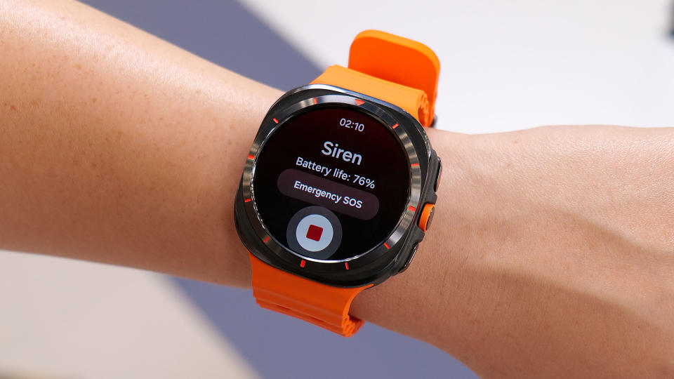 The Samsung Galaxy Watch Ultra on a wrist in mid air, with its screen showing the words 