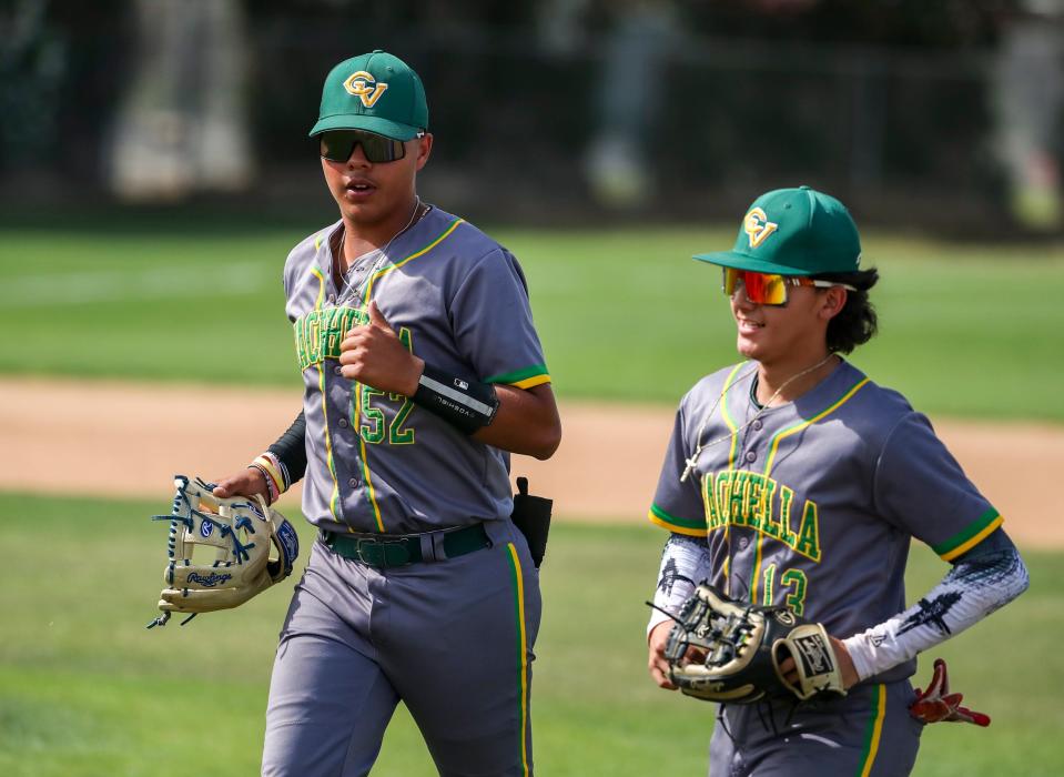 Coachella Valley's Rudy Borjas (52) jogs into the dugout with Luis Zamora after making a play for a third out during their game at Coachella Valley High School in Thermal, Calif., Tuesday, May 9, 2023. 