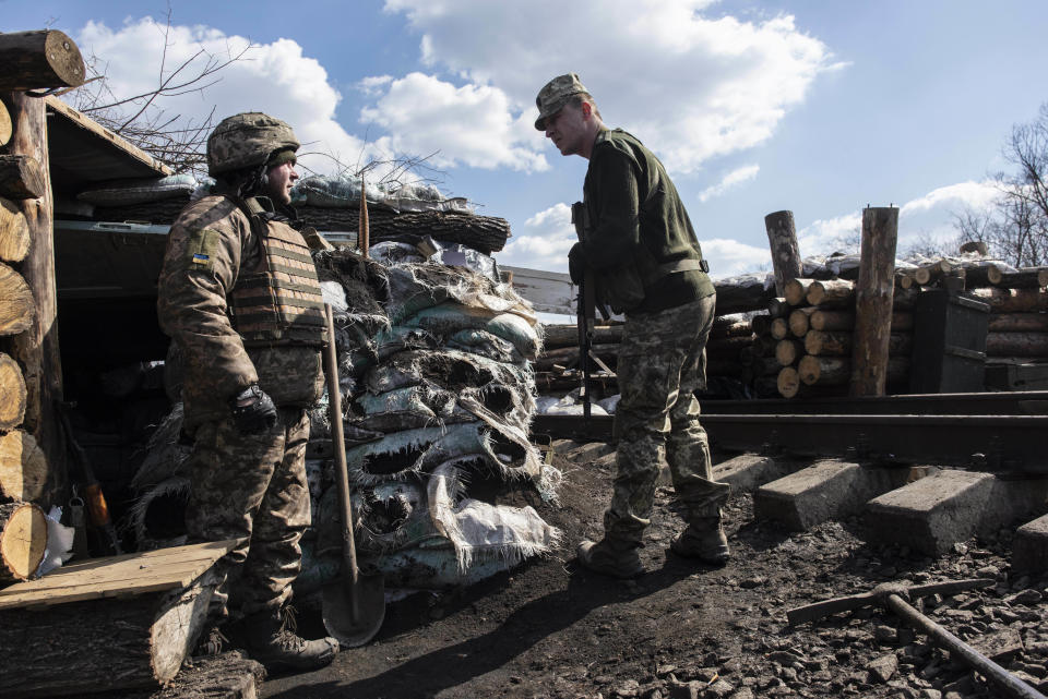 A Ukrainian solder speaks to his comrade at a position on the contact line in the village of Zolote 4, eastern Ukraine, Friday, March 29, 2019. Five years after a deadly separatist conflict in eastern Ukraine, the front line between government forces and Russia-backed separatists has become a de-facto border, cutting off a generation of first-time voters from Sunday's presidential election. (AP Photo/Evgeniy Maloletka)