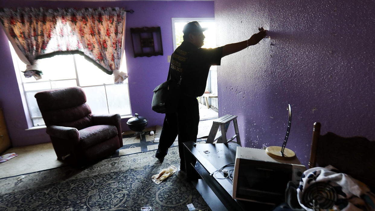 Community organizer Alain Cisneros easily puts his hand through a soaked wall in a Rockport Apartment that was damaged by Tropical Storm Harvey on Thursday, Sept. 7, 2017, in Houston.