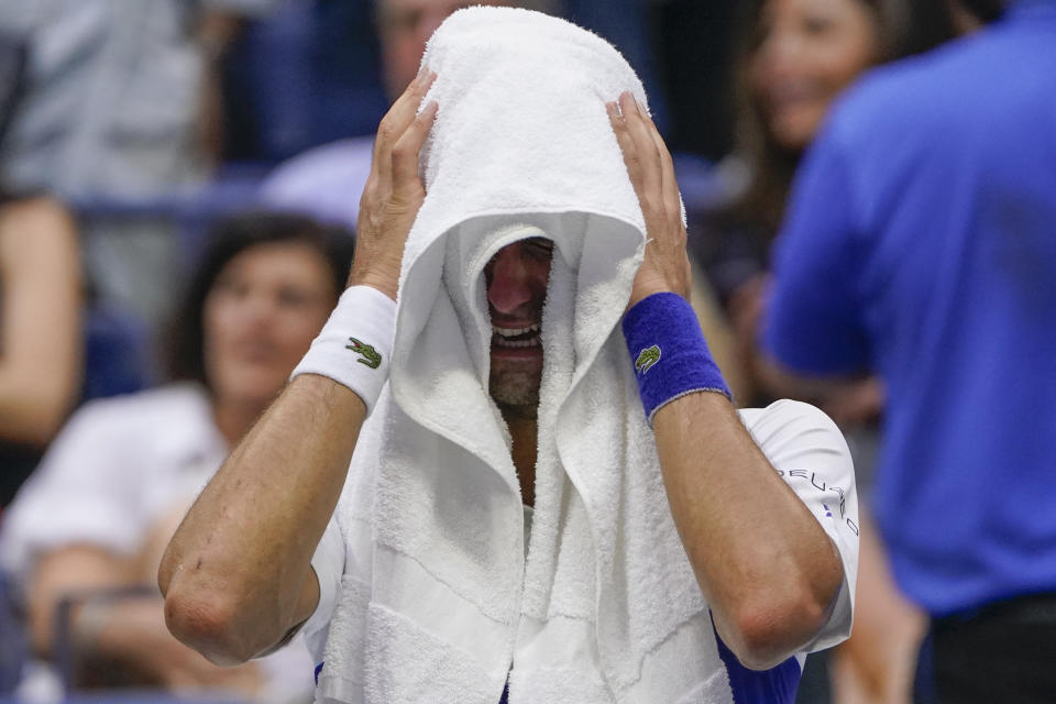 Novak Djokovic, of Serbia, cries as he sits on his bench during a changeover in the third set of the men's singles final against Daniil Medvedev, of Russia, of the US Open tennis championships, Sunday, Sept. 12, 2021, in New York. (AP Photo/John Minchillo)