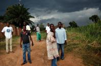 Men stand outside their neighborhood near the airport in Bangui, Central African Republic, Monday Dec. 9, 2013. Both Christian and Muslim mobs went on lynching sprees as French Forces deployed in the capital. French forces fired warning shots to disperse the crowds. (AP Photo/Jerome Delay)