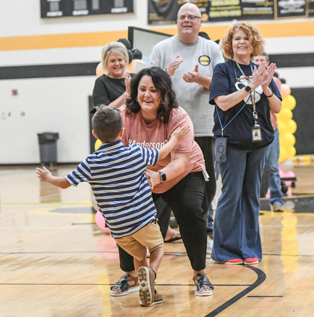 Heather Dickerson, support staffer of the year, opens her arms to her son Brooks, running to her celebrating her award with family and fellow teachers, during the Anderson School District 3 teacher and staff school kickoff in the Crescent High School gymnasium in Iva, S.C. Friday, July 26, 2024.