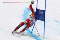 Switzerland's Gino Caviezel attempts to clears a gate during the first run of the men's alpine skiing giant slalom event at the 2014 Sochi Winter Olympics at the Rosa Khutor Alpine Center February 19, 2014. REUTERS/Stefano Rellandini (RUSSIA - Tags: SPORT SKIING OLYMPICS)