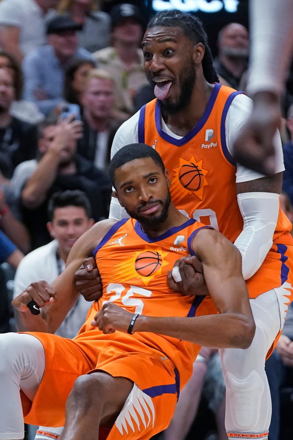 Phoenix Suns forward Jae Crowder, rear, helps forward Mikal Bridges from the floor following a foul by the Utah Jazz during the second half of an NBA basketball game Friday, April 8, 2022, in Salt Lake City.