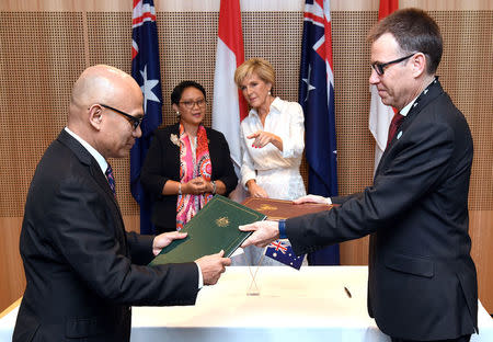 Australia's Foreign Minister Julie Bishop stands with her Indonesian counterpart Retno Marsudi talk as Indonesia's Director General of Asia Pacific and African Affairs exchanges documents with Richard Maude from Australia's Department of Foreign Affairs and Trade during the Australia-Indonesia Maritime Cooperation Plan of Action signing ceremony in Sydney, Australia, March 16, 2018. William West/Pool via REUTERS