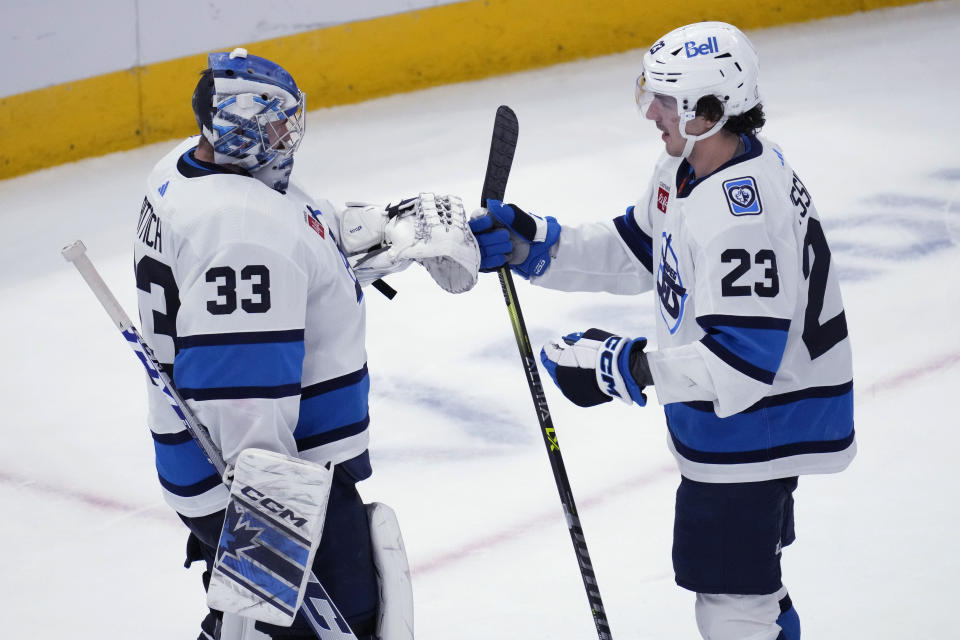Winnipeg Jets goaltender David Rittich, left, celebrates with center Michael Eyssimont after the Jets defeated the Chicago Blackhawks 3-1 in an NHL hockey game in Chicago, Friday, Dec. 9, 2022. (AP Photo/Nam Y. Huh)