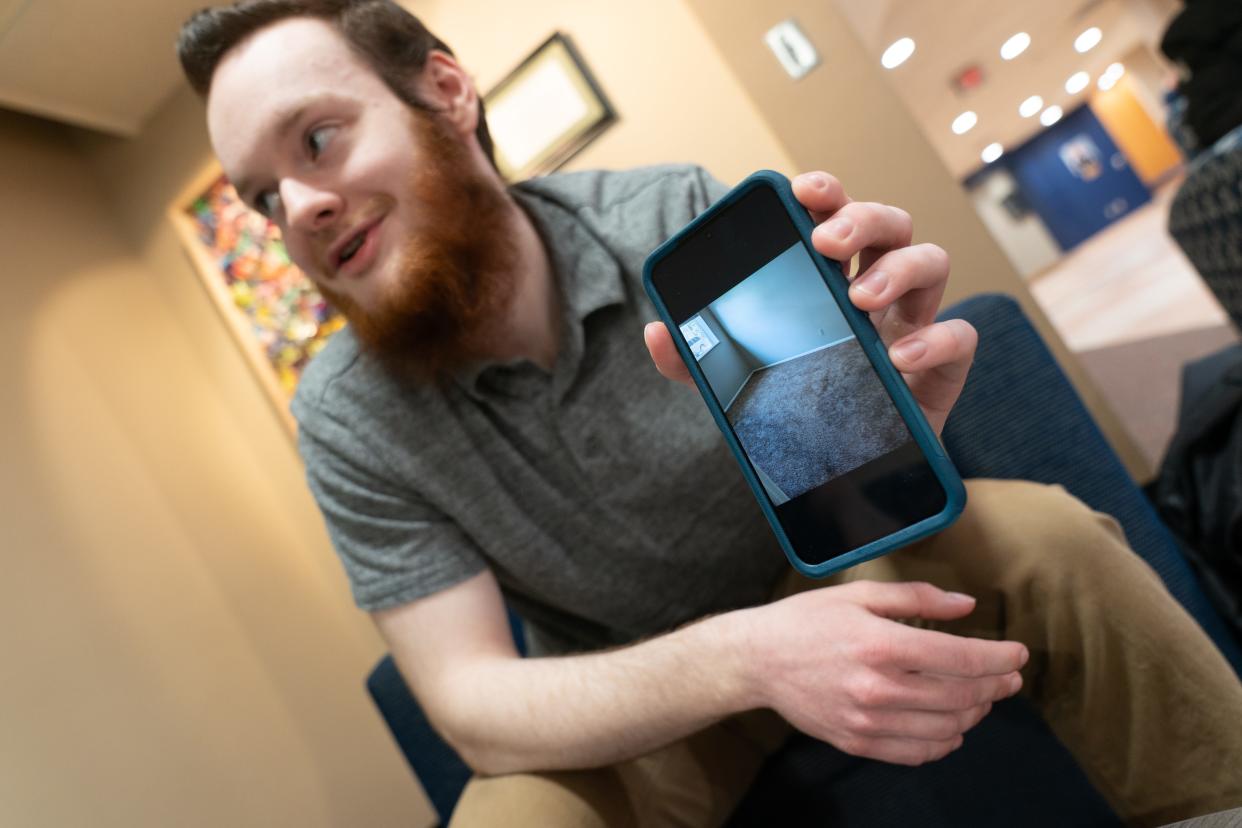 Gabriel Kniffen shows a photo of the carpet taken in August 2021 when he moved into a Washburn Arms apartment building at 1930 S.W. Washburn Ave. He said apartment management billed him for cleaning the carpet, but it was already dirty when he moved in.